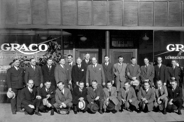 Men in front of Graco building