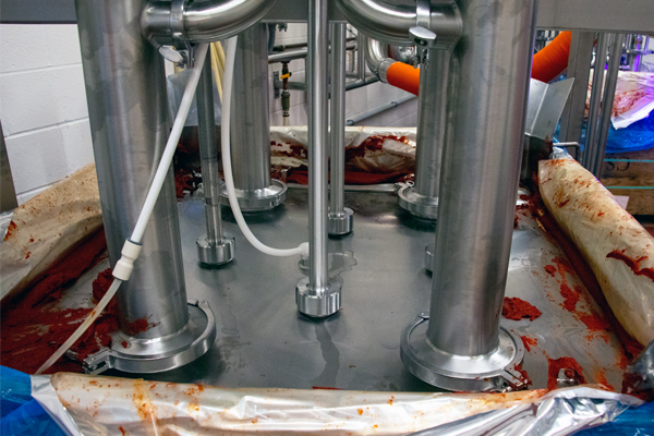 SaniForce®-Behälterentleerungssystem mit vier Kolbenpumpen beim Entladen von Tomatenmark